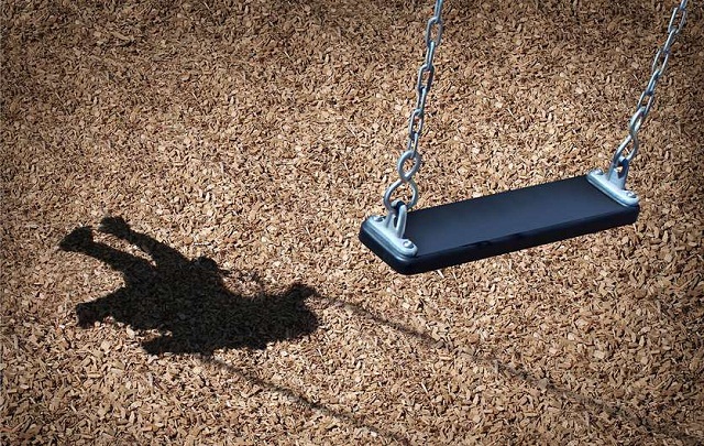 An empty swing with a child in the shadow Lost Child