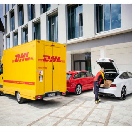 A Yellow Truck and a Delivery Man Putting a Package Into the Rear of the Car