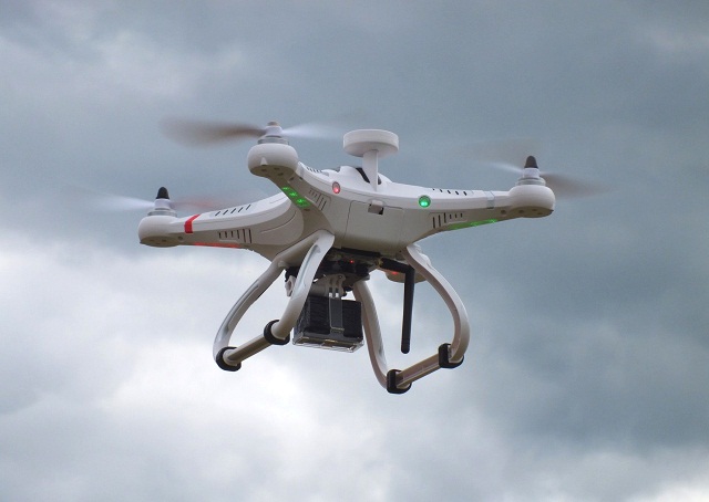 A white drone flying Flying Drone
